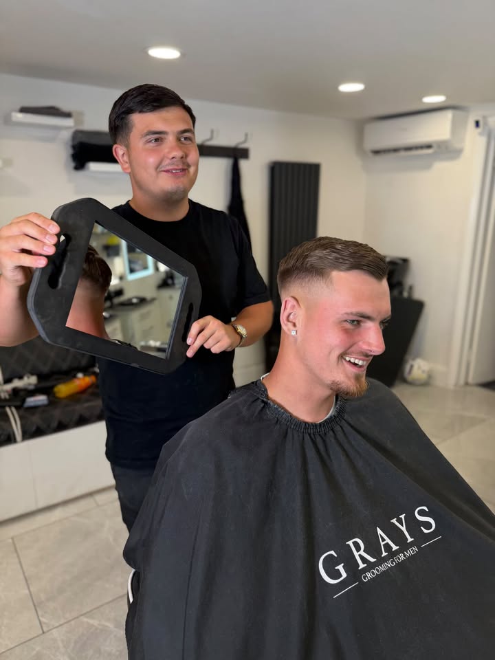 A fresh skin fade being shown to a happy Grays client